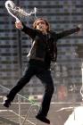 Bono, lead singer of Irish rock band U2, sprays water as he performs during a concert at the King Baudouin Stadium in Brussels June 10, 2005. U2 is currently on their 'ertigo 2005' world tour with Brussels as the first concert in Europe. REUTERS/Str