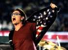 U2 lead singer Bono show the Stars and Stripes of the US flag on the inside of his jacket during the band's halftime Super Bowl XXXVI performance in New Orleans February 3, 2002. The New England Patriots meet the St. Louis Rams in the matchup. REUTERS/Win Mcnamee